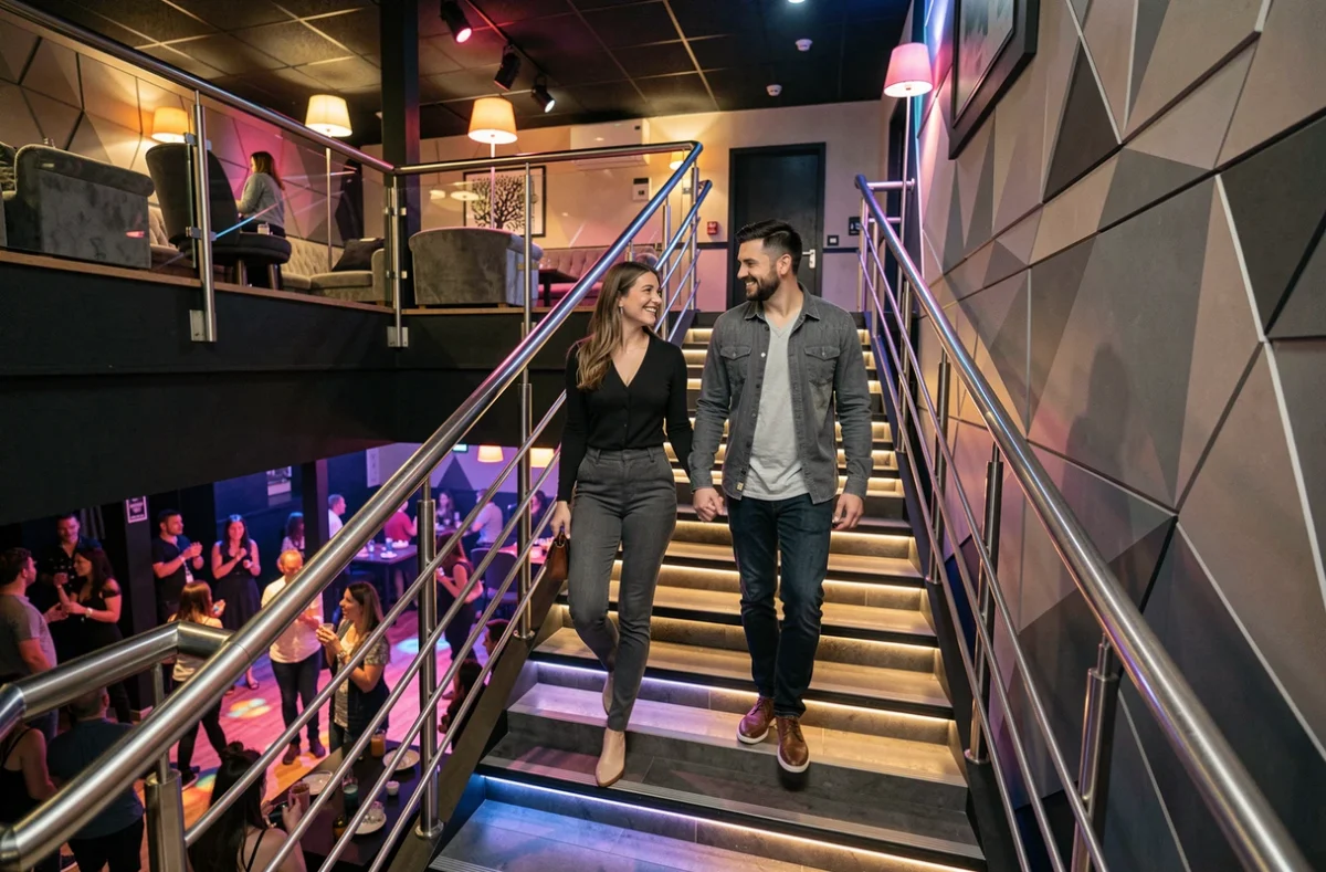 Couple souriant descendant l'escalier design de la discothèque Le Stairway à Lille